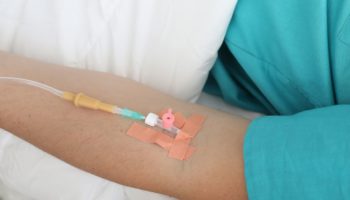 Medical professional hands preparing intravenous medication syringe
